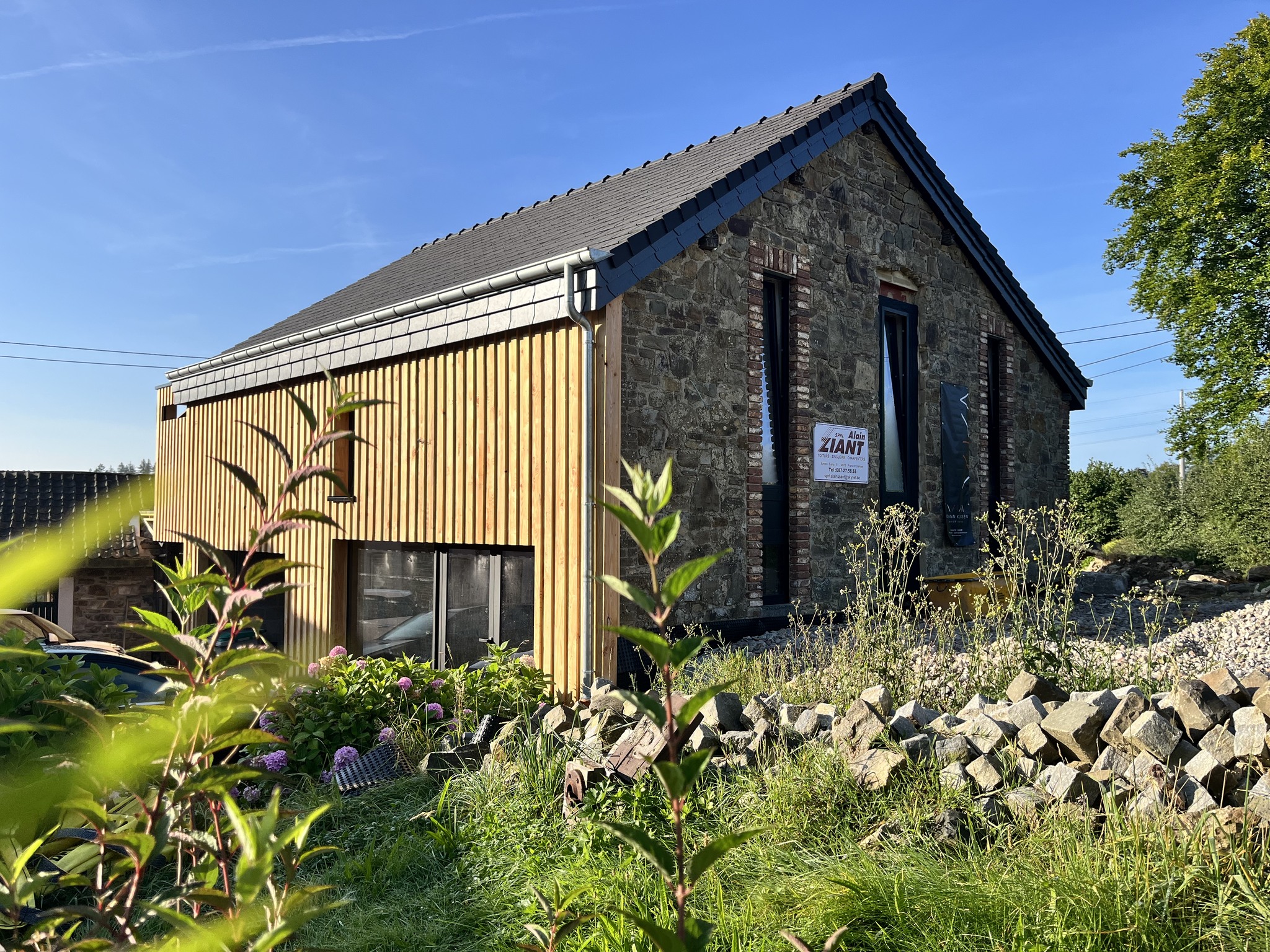 Maison en pierre et bois réalisée par YKAAR architecte à Jalhay